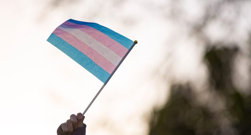 A protester waves a transgender pride flag during a protest against an anti-trans guest speaker